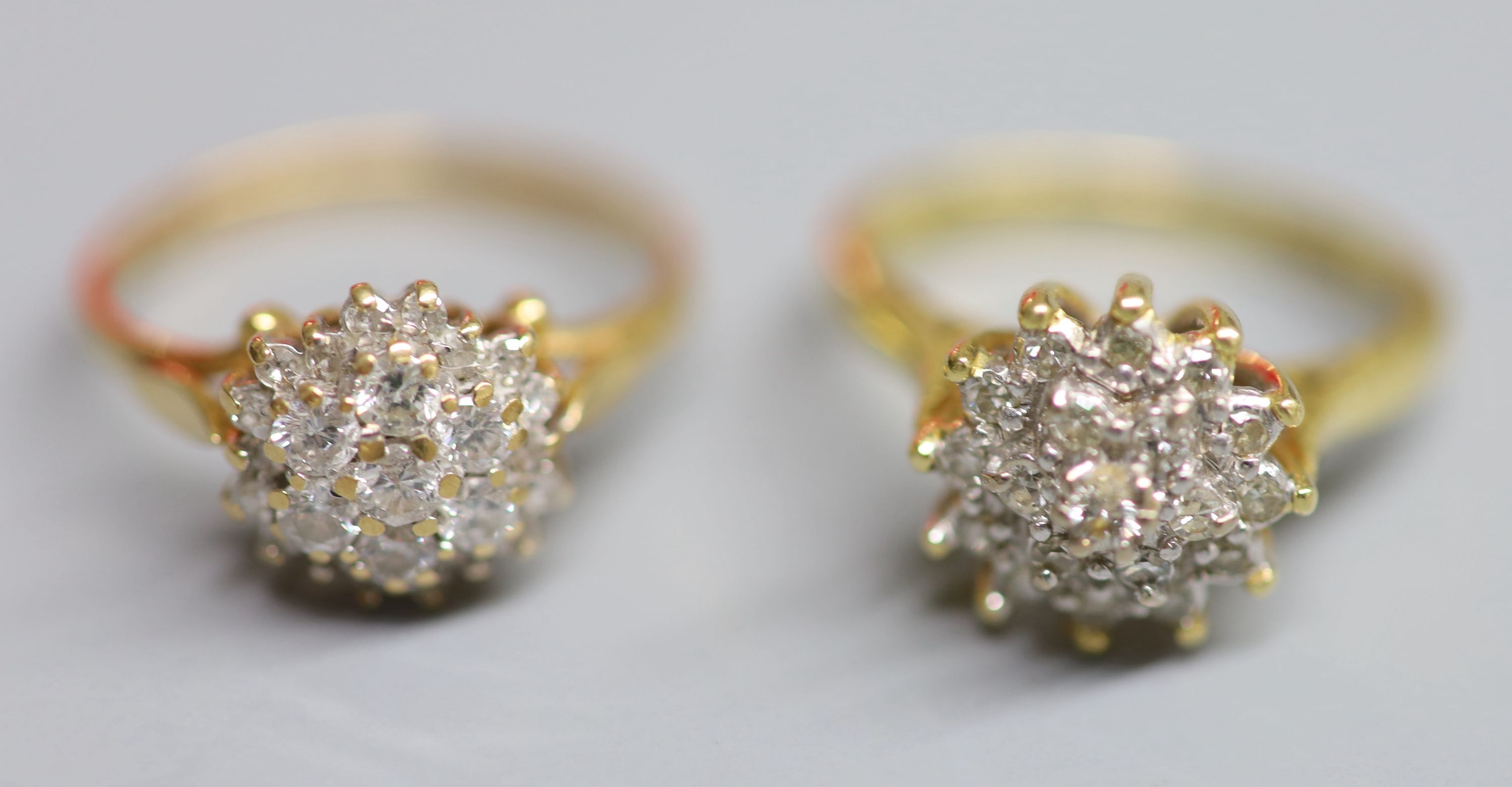Two modern 18ct gold and diamond cluster dress rings, sizes J/K & N, gross weight 7.4 grams.